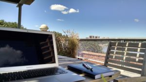 Laptop on table on roof garden with blue skies